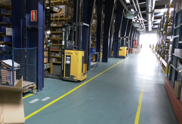 Warehouse aisle at Hydra Specma with natural light streaming in from the far end