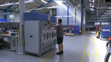dark haired man operating a large baler at hydra specma