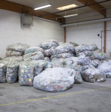 a large pile of clear bags filled with empty pet bottles