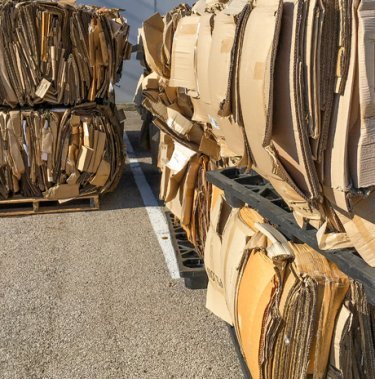 bales from a recycling baler in stacks on asphalt
