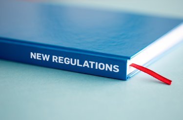 blue book on table with text 'new regulations' for workplace recycling