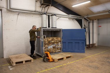 man operating pneumatic baler
