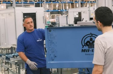 man explaining vertical baler safety features to another man
